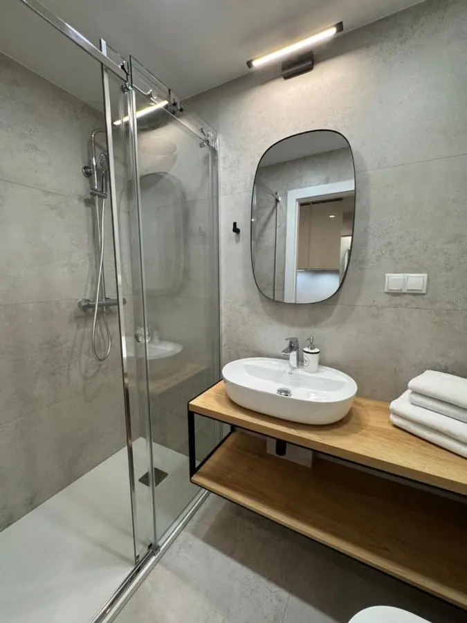 Shower room with a glass walk-in shower and an oval mirror