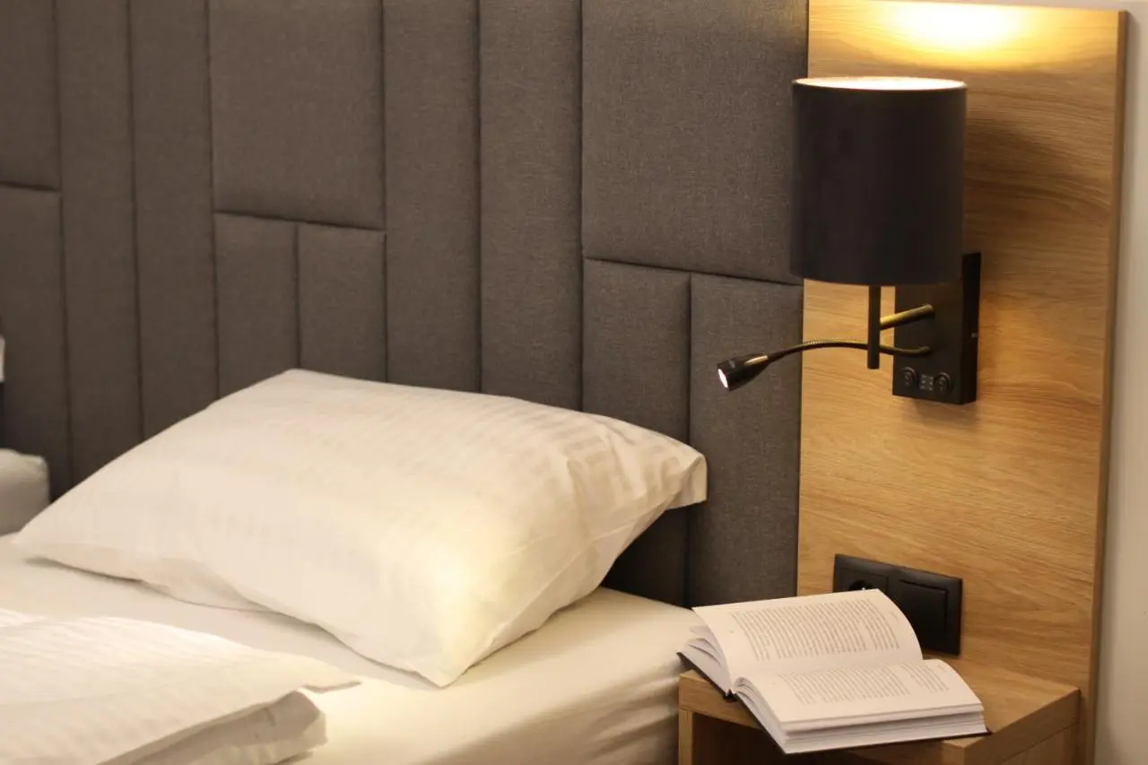 A book on the bedside shelf under the reading lamp