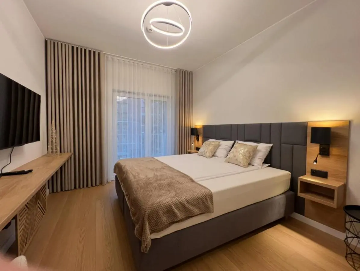 Double bed with an upholstered headboard and a window onto the courtyard